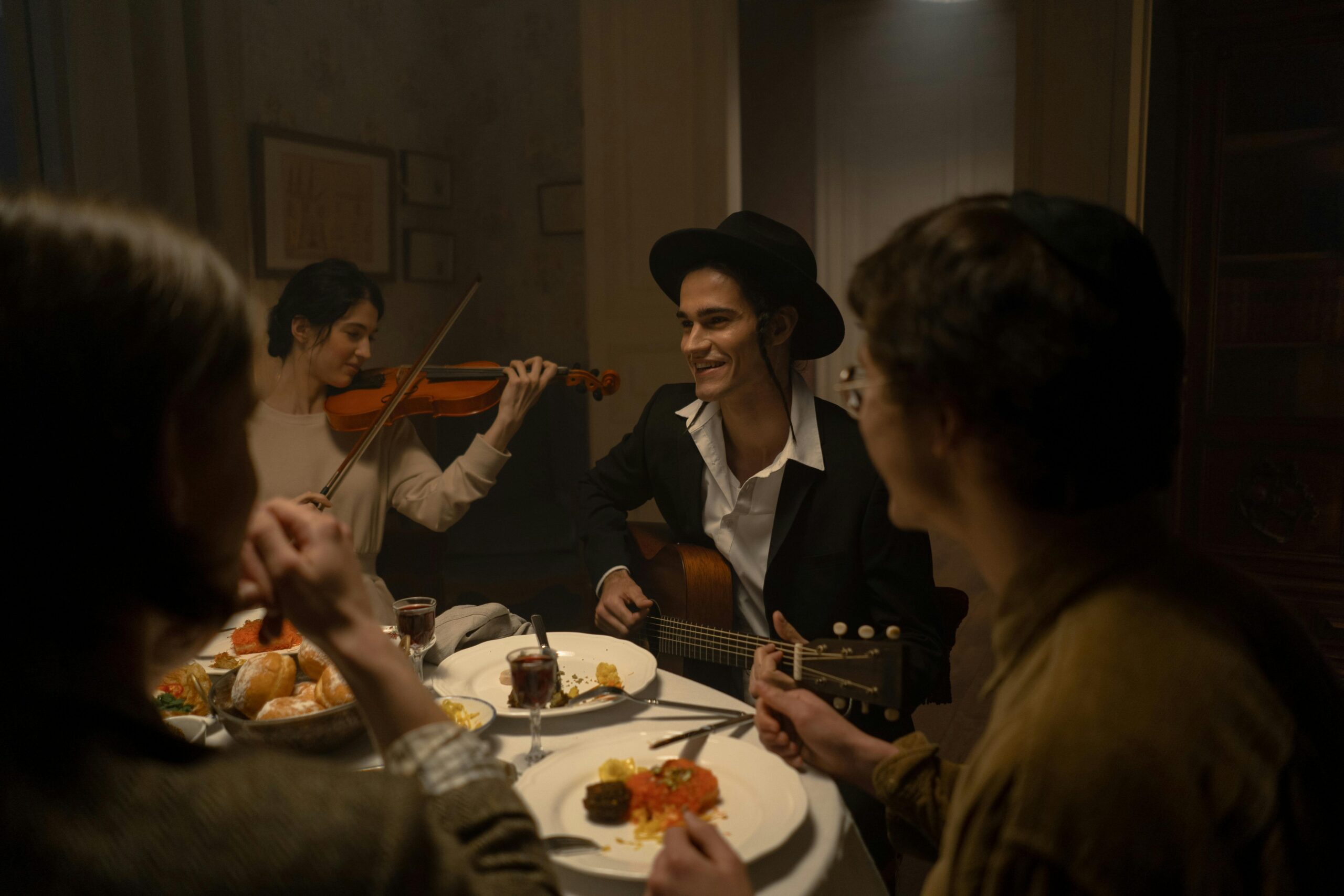 Celebratory Hanukkah dinner with friends, featuring live music and traditional Jewish cuisine in a cozy indoor setting.